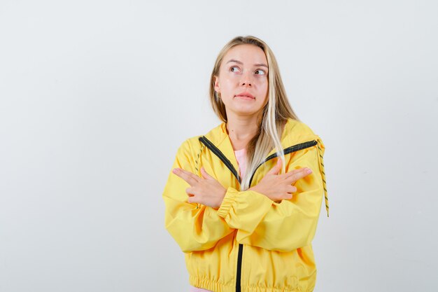 Tシャツ、ジャケットで銃のジェスチャーを示し、自信を持って見える若い女性