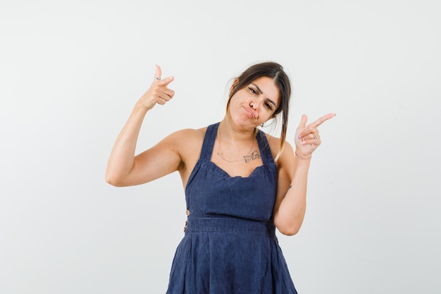 Young lady showing shooting gesture in dress and looking confident