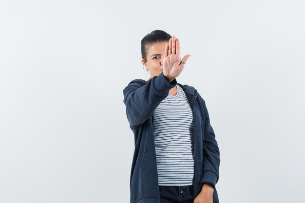 Young lady showing stop gesture in t-shirt
