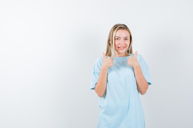 Young lady showing thumbs up in t-shirt and looking happ isolated