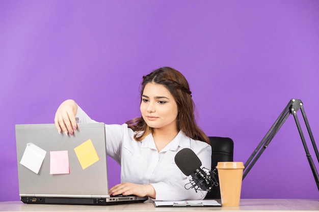 Young lady sittin at the desk and opening her notebook High quality photo