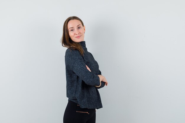 Young lady standing with crossed arms in shirt