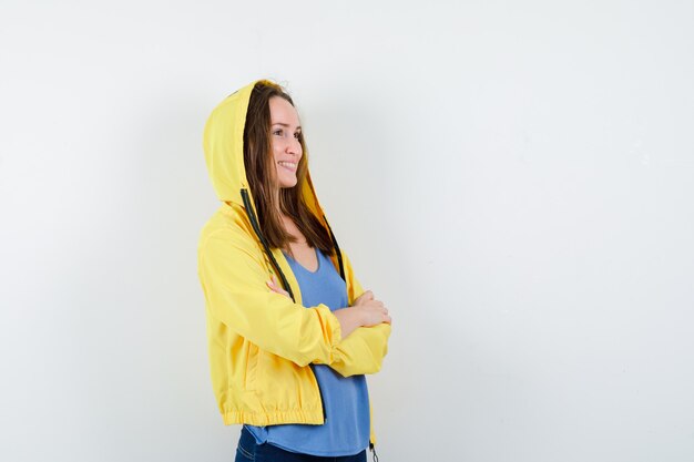 Young lady standing with crossed arms in t-shirt, jacket and looking confident. front view.