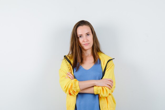 Young lady standing with crossed arms in t-shirt and looking confident. front view.