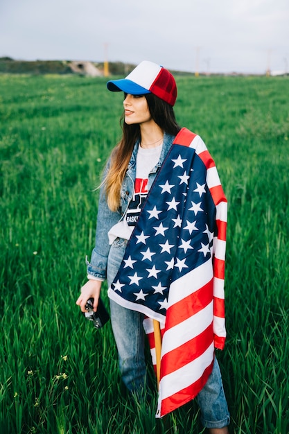 Young Lady staying in field with American flag