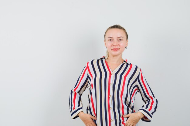 Young lady in striped shirt posing while standing and looking beautiful