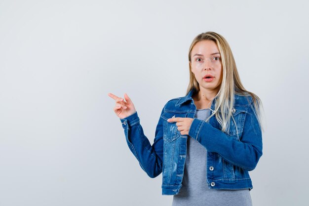 Tシャツ、デニムジャケット、脇を向いて驚いているスカートの若い女性