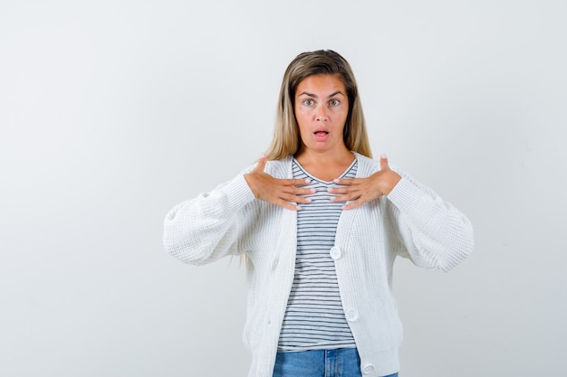 Foto gratuita giovane donna in t-shirt, giacca tenendo le mani sul petto e guardando sorpreso, vista frontale.