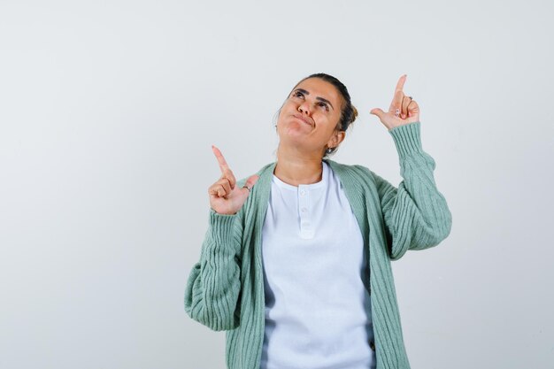 Young lady in t-shirt, jacket pointing away and looking thoughtful