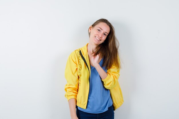 Young lady in t-shirt, jacket posing while standing and looking charming, front view.