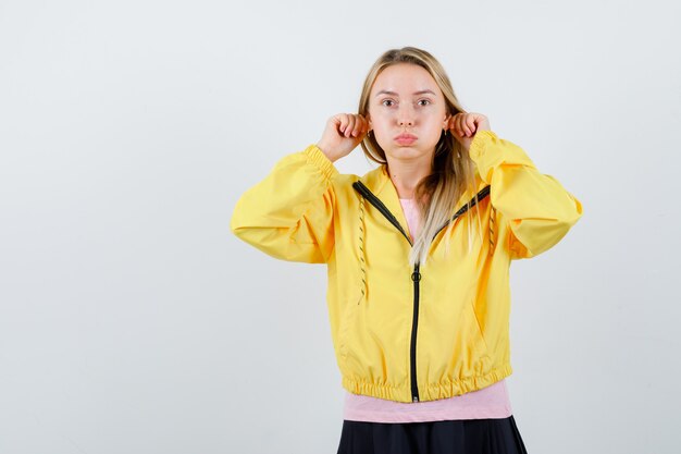 Free photo young lady in t-shirt, jacket showing funny gesture while blowing cheeks and looking funny