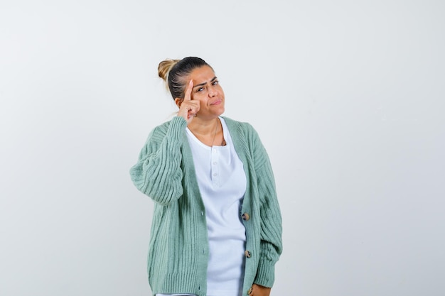 Young lady in t-shirt, jacket standing in thinking pose and looking pensive