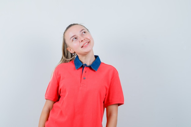 見上げて楽観的に見えるTシャツの若い女性