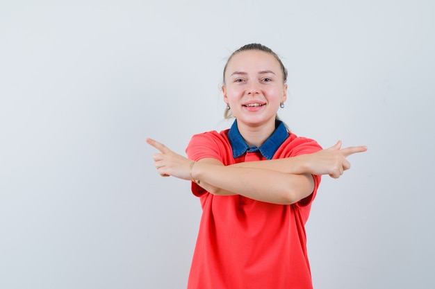 Free photo young lady in t-shirt pointing away and looking frisky