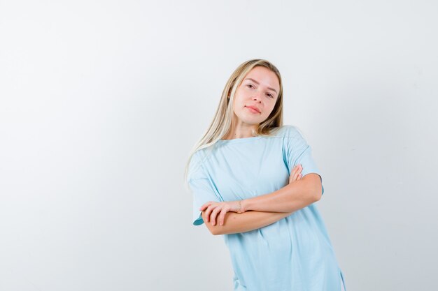 Young lady in t-shirt standing with crossed arms and looking confident , front view.