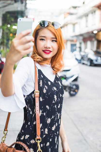 거리에서 selfie를 복용하는 젊은 아가씨