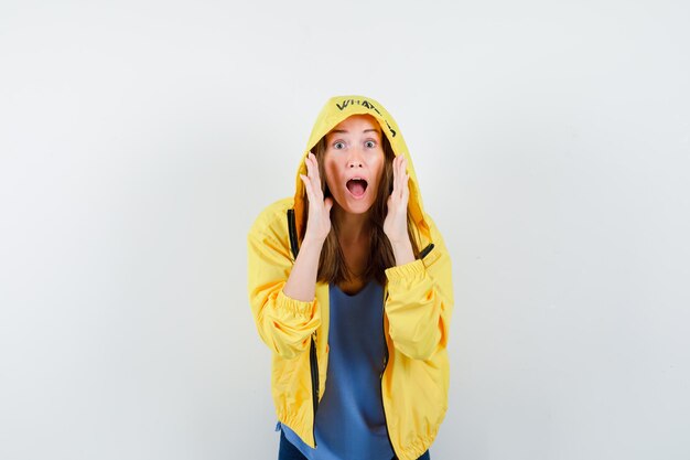 Young lady telling secret or announcing something in t-shirt, jacket and looking excited