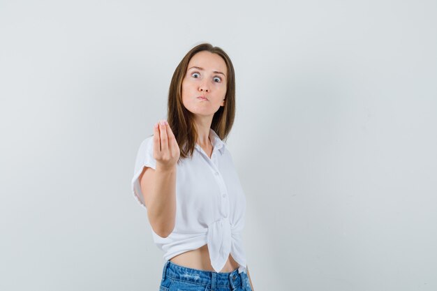 Young lady trying to explain something in white blouse and looking nervous. front view.