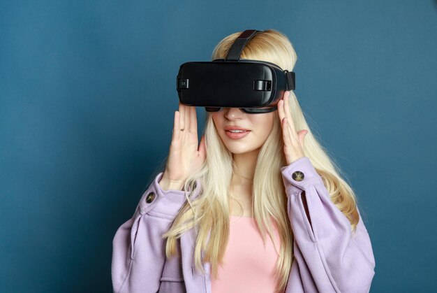 Young lady wearing VR glasses on holding her hands on it