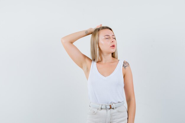 Young lady in white blouse suffering from headache and looking painful