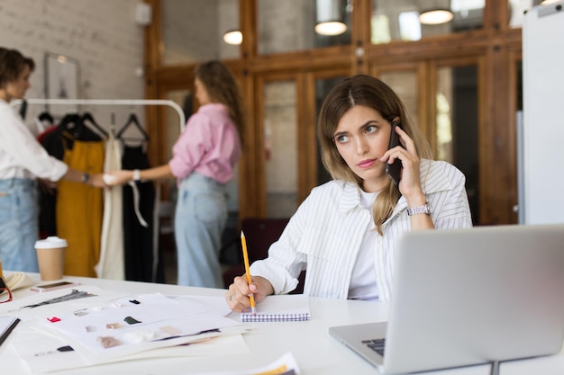 Young lady in white striped shirt with pencil and notepad though