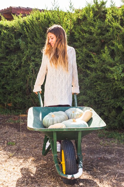 Young lady with fresh vegetables in utility cart