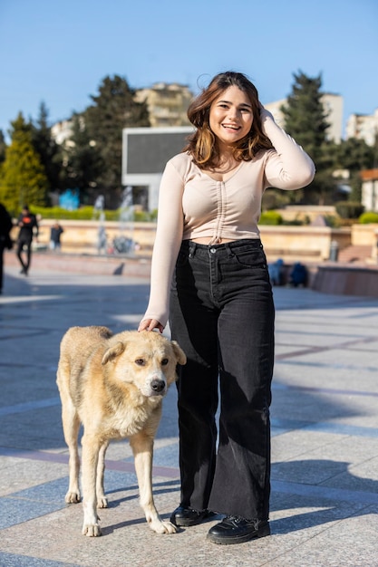 Giovane donna con cane senzatetto al parco foto di alta qualità