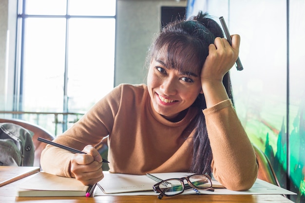 Young lady with pens at table 