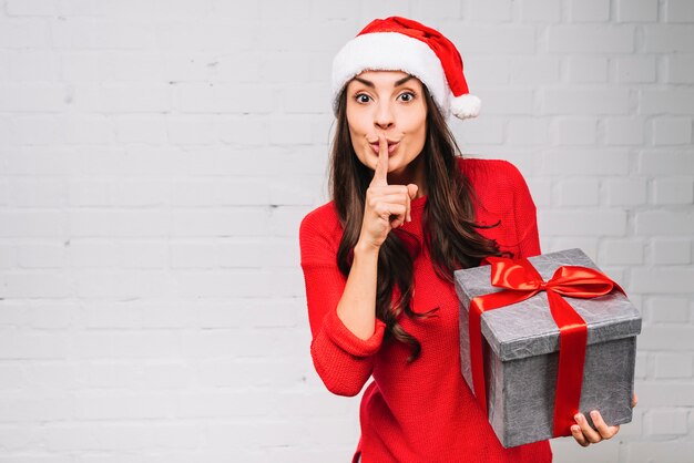 Young lady with present box showing silent 