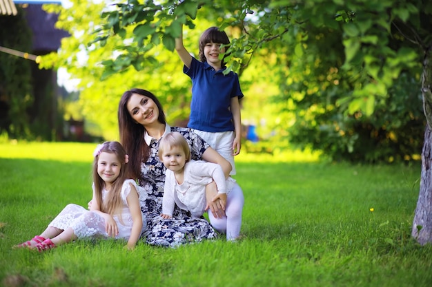 Молодая большая семья на летней утренней прогулке красивая мама с детьми играет в парке Premium Фотографии