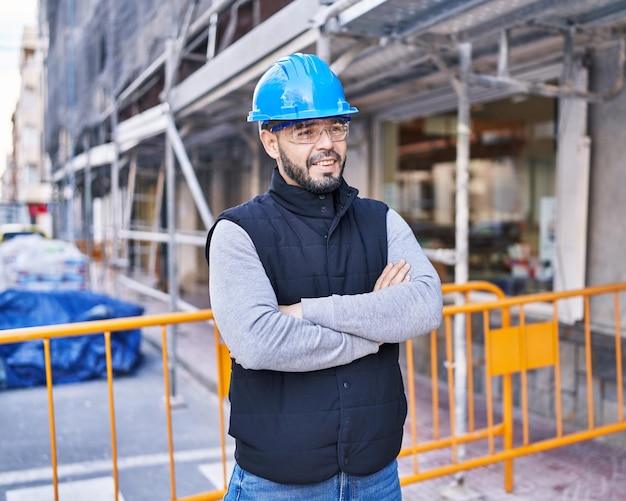 Young latin man architect smiling confident standing with arms crossed gesture at street