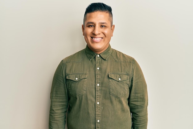 Young latin man wearing casual clothes with a happy and cool smile on face lucky person