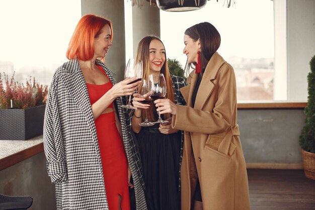 Young laughing friends drinking rose wine from glass outside.