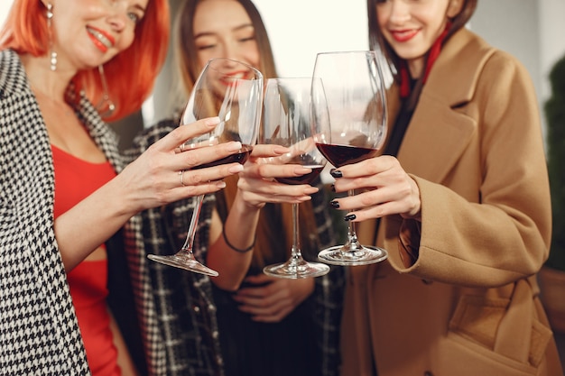 Young laughing friends drinking rose wine from glass outside.