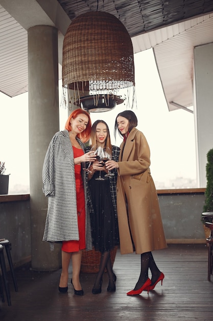 Young laughing friends drinking rose wine from glass outside.