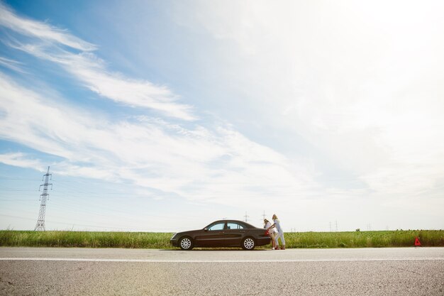 Young lesbian's couple going to vacation trip on the car in sunny day