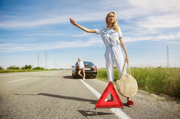 Young lesbian's couple going to vacation trip on the car in sunny day