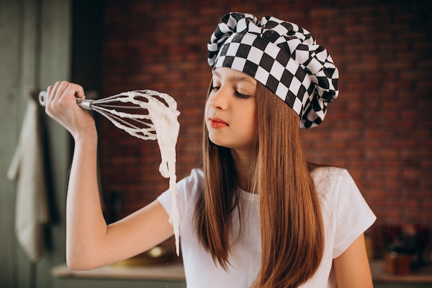 Young little girl baking pastry at the kitchen for breakfast