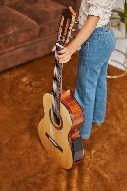 Young little girl playing guitar at home