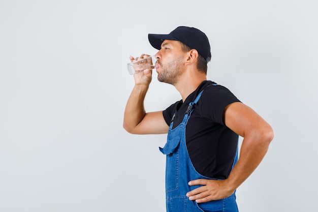 若いローダーは水を飲み、制服を着て暑く感じます。