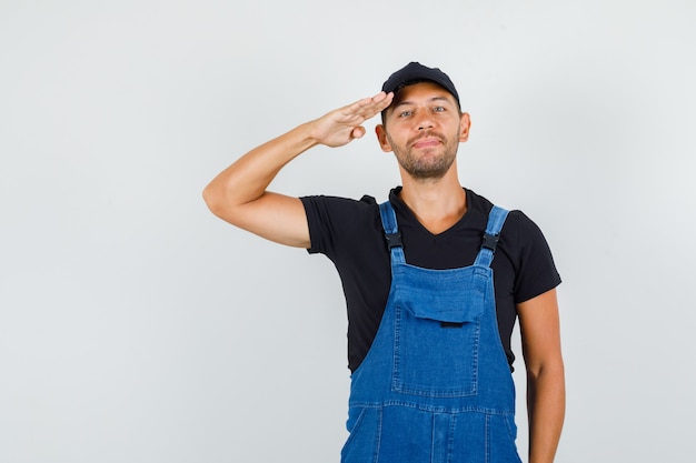 Foto gratuita giovane caricatore in uniforme che saluta e sorridente, vista frontale.