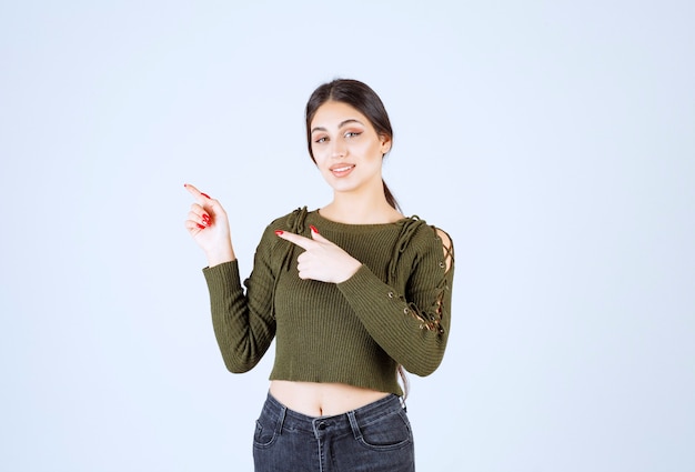 Una giovane donna adorabile modello in verde che punta al suo fianco