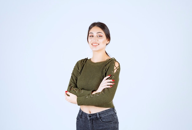 Free photo a young lovely woman model in green standing arms crossed