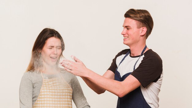 Young loving couple playing with flour