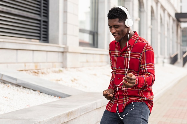 Free photo young male adult listening to music and dancing