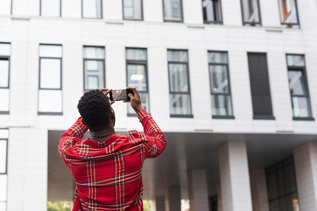 Free photo young male adult taking pictures of a building