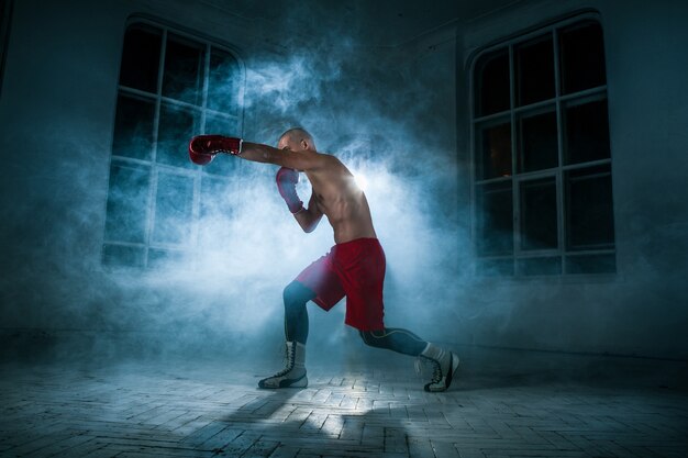 若い男性アスリートキックボクシングの青い煙