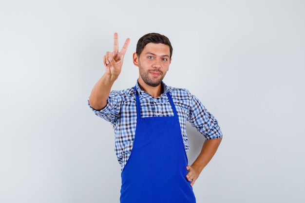 Young male cook in a blue apron and a shirt