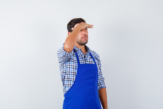 Young male cook in a blue apron and a shirt