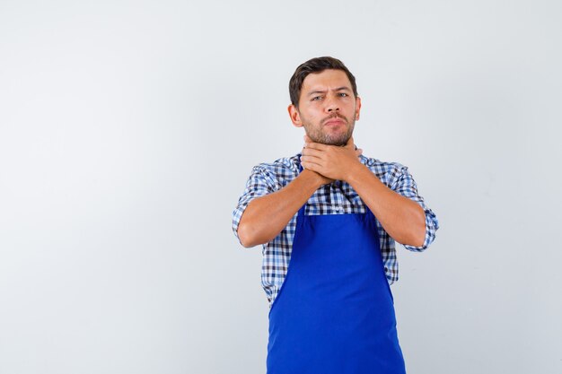 Young male cook in a blue apron and a shirt